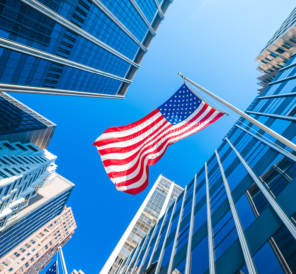 USA flag and contemporary glass architecture of Financial District, New York City, USA.