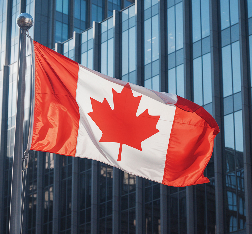 Image du drapeau canadien flottant au vent devant un immeuble de bureaux.